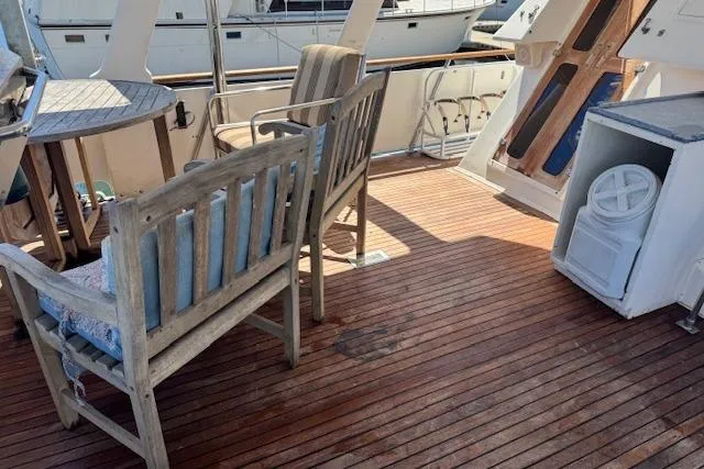 Slide: The Image of 1985 Spindrift Trawler deck with wooden seating and table, showcasing nautical elegance. - 17