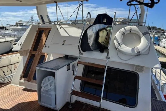 Slide: The Image of 1985 Spindrift Trawler deck with ladder, life preserver, and marina view. - 18