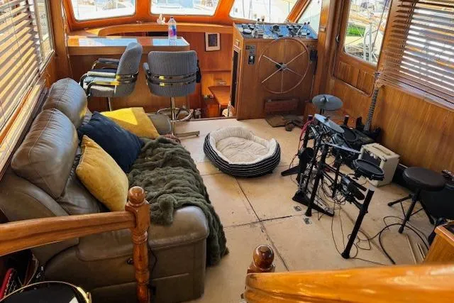 Slide: The Image of 1985 Spindrift Trawler interior with cozy seating, musical instruments, and nautical decor. - 19