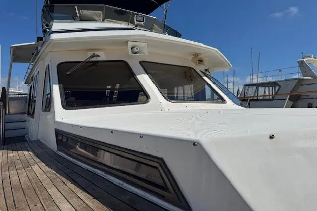Slide: The Image of 1985 Spindrift Trawler with white exterior, docked under a clear blue sky. - 21
