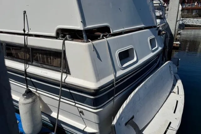 Slide: The Image of 1985 Spindrift Trawler docked, showing rear view with fender and swim platform. - 3