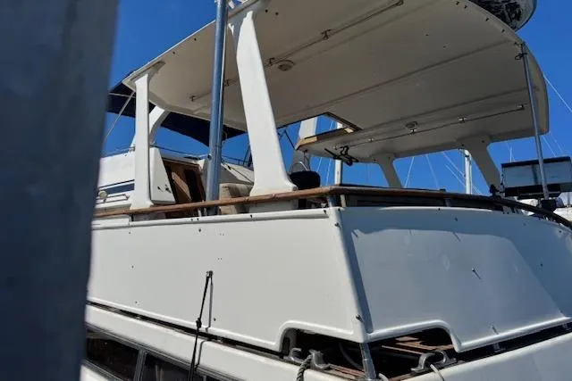 Slide: The Image of 1985 Spindrift Trawler boat with white exterior and spacious deck under clear blue sky. - 4