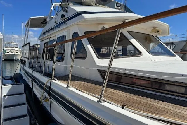 Slide: The Image of 1985 Spindrift Trawler docked at marina, showcasing classic design and spacious deck. - 9