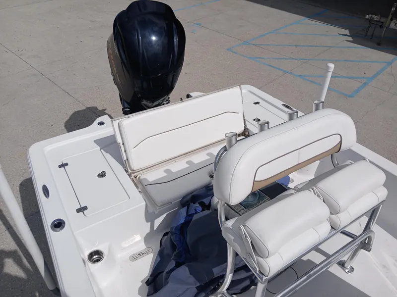 Slide: The Image of 2015 Sportsman Tournament 234 Bay Boat interior with seating and motor, in a parking area. - 12