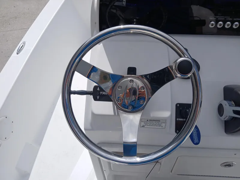Slide: The Image of Steering wheel of a 2015 Sportsman Tournament 234 Bay Boat, featuring chrome accents. - 4