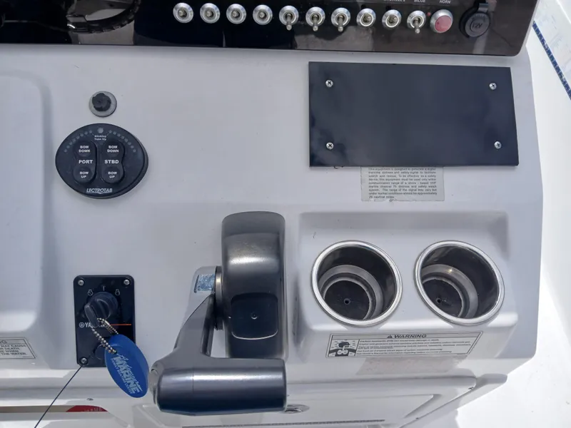 Slide: The Image of Control panel of a 2015 Sportsman Tournament 234 Bay Boat with switches and cup holders. - 5