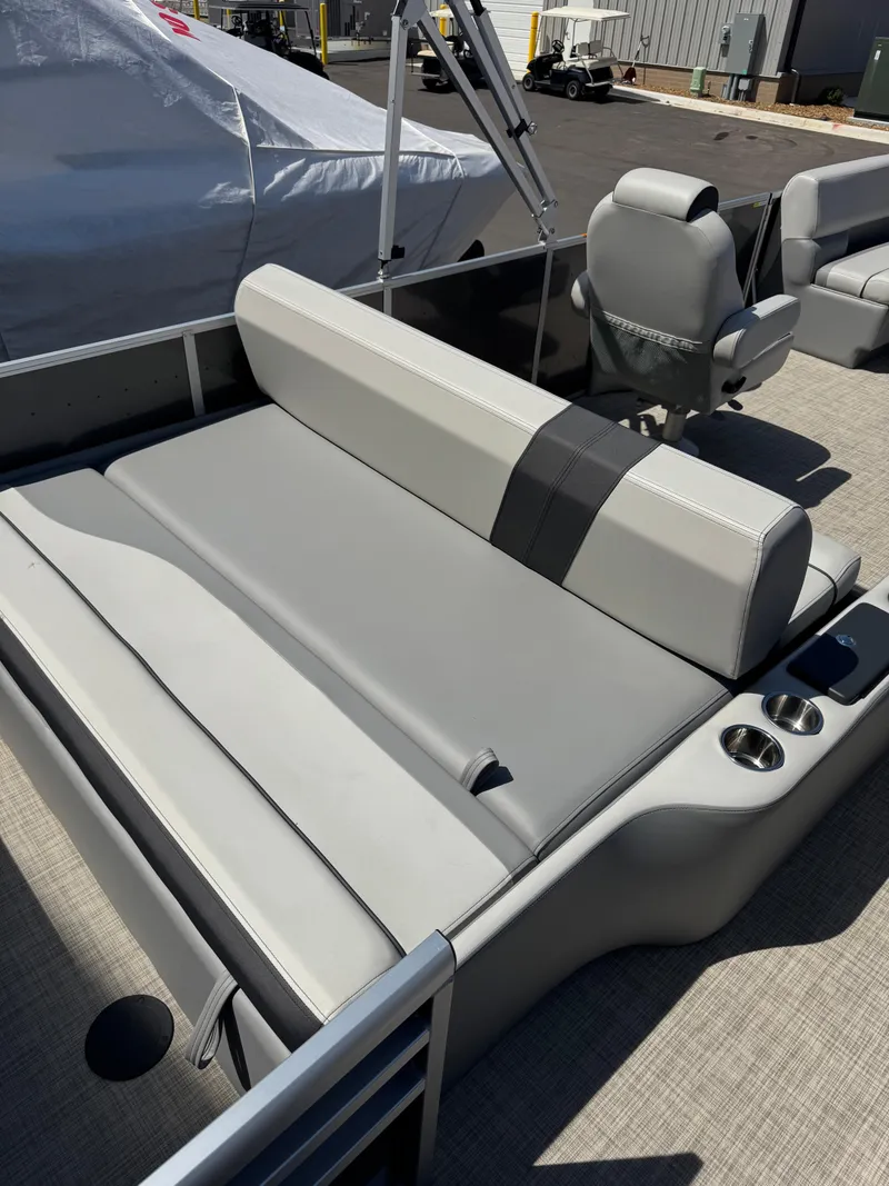 Slide: The Image of 2025 SunCatcher Select 324SL boat interior with gray seating and cup holders. - 2