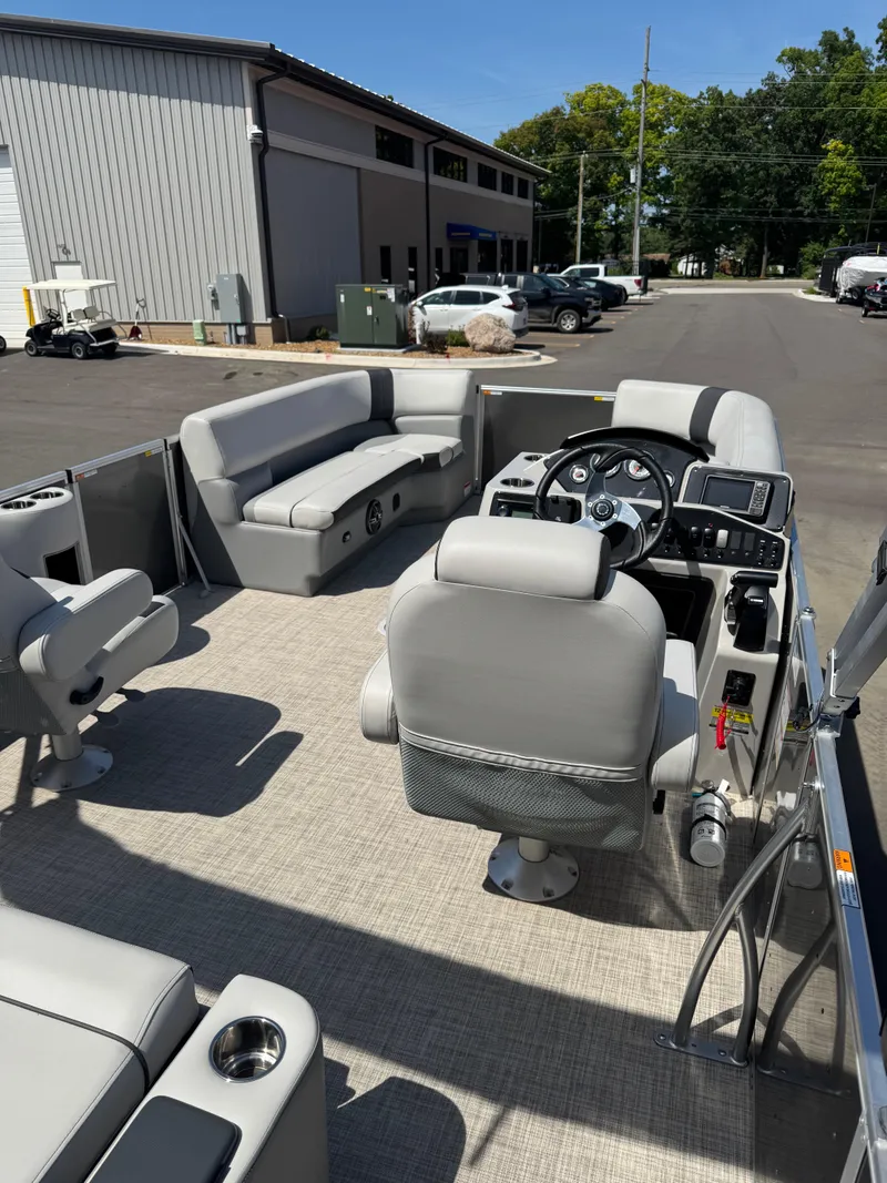 Slide: The Image of 2025 SunCatcher Select 324SL pontoon boat interior with gray seating and modern dashboard. - 4