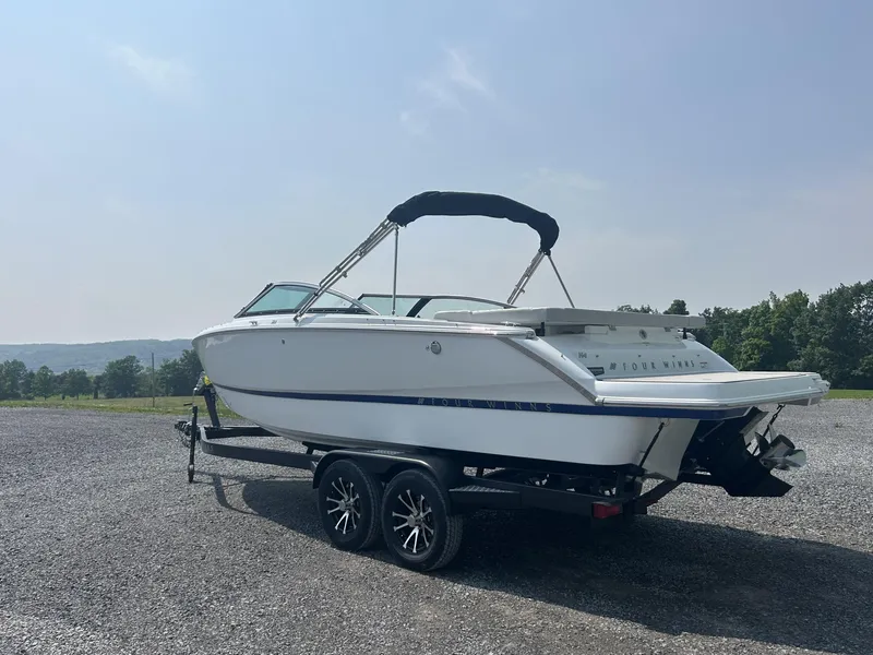The Image of 2026 Four Winns H4 Freedom boat on trailer, parked outdoors under clear sky. - 1
