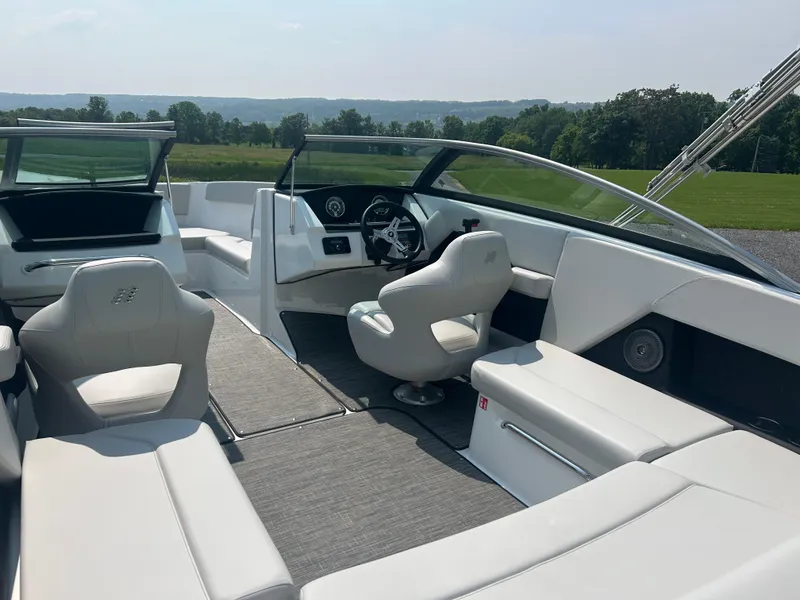 Slide: The Image of 2026 Four Winns H4 Freedom boat interior with sleek white seating and modern dashboard. - 10