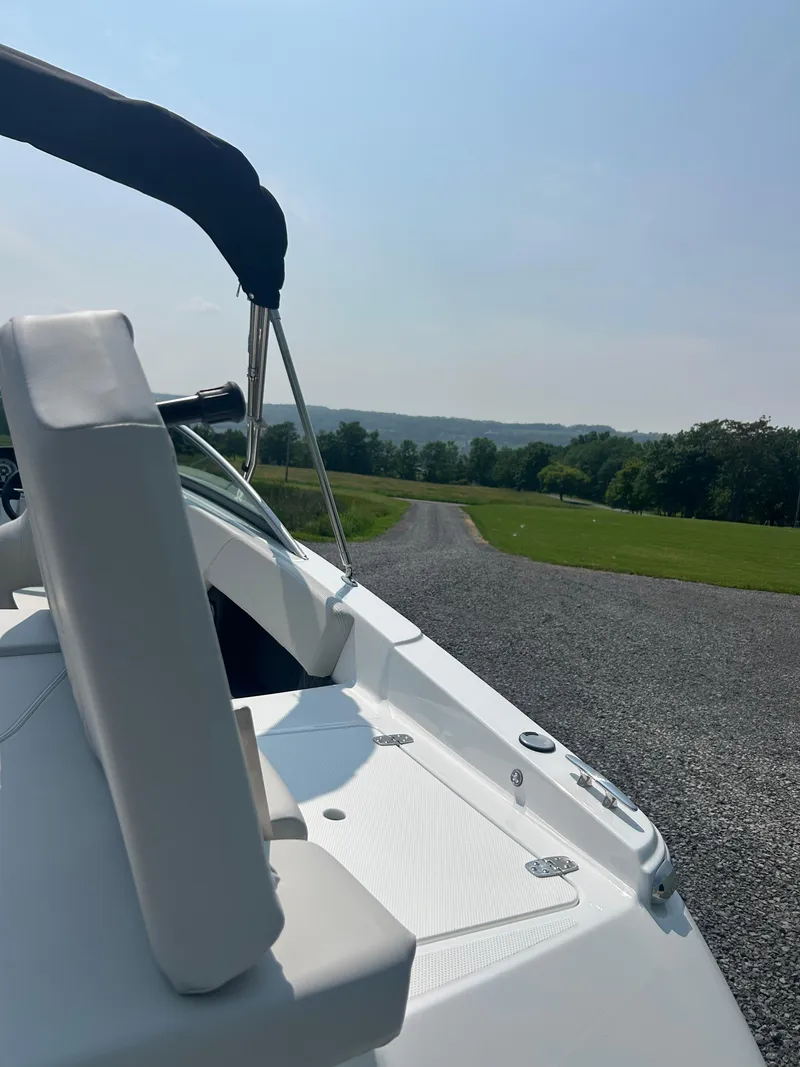 Slide: The Image of 2026 Four Winns H4 Freedom boat on a gravel path with scenic countryside view. - 16