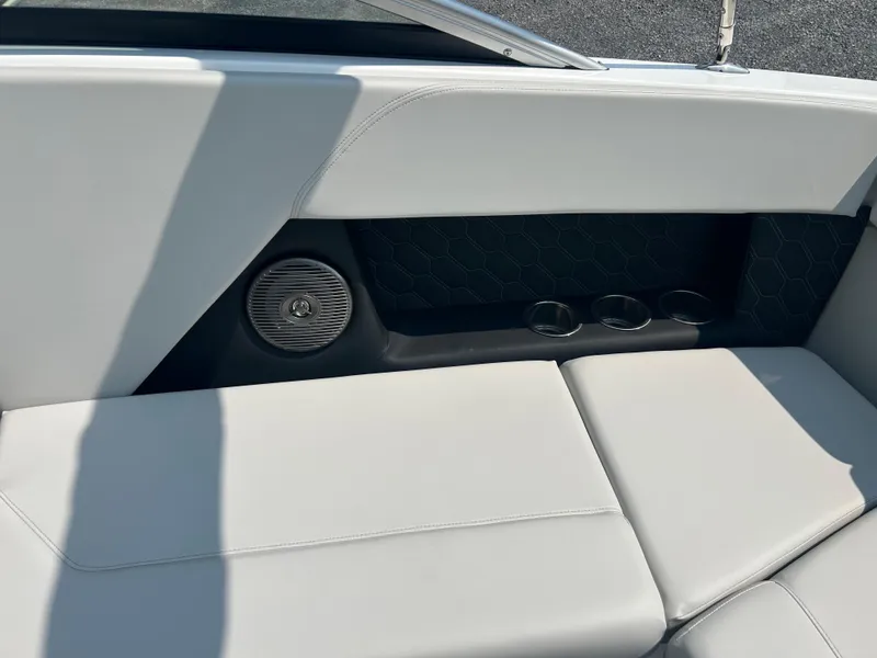 Slide: The Image of 2026 Four Winns H4 Freedom boat interior with white seating, speaker, and cup holders. - 19