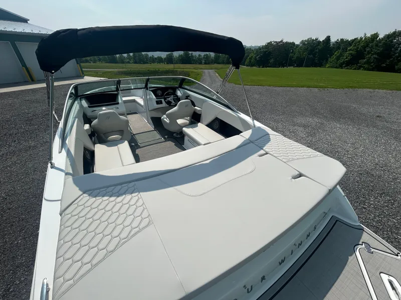 Slide: The Image of 2026 Four Winns H4 Freedom boat with sleek interior and canopy, parked outdoors. - 6