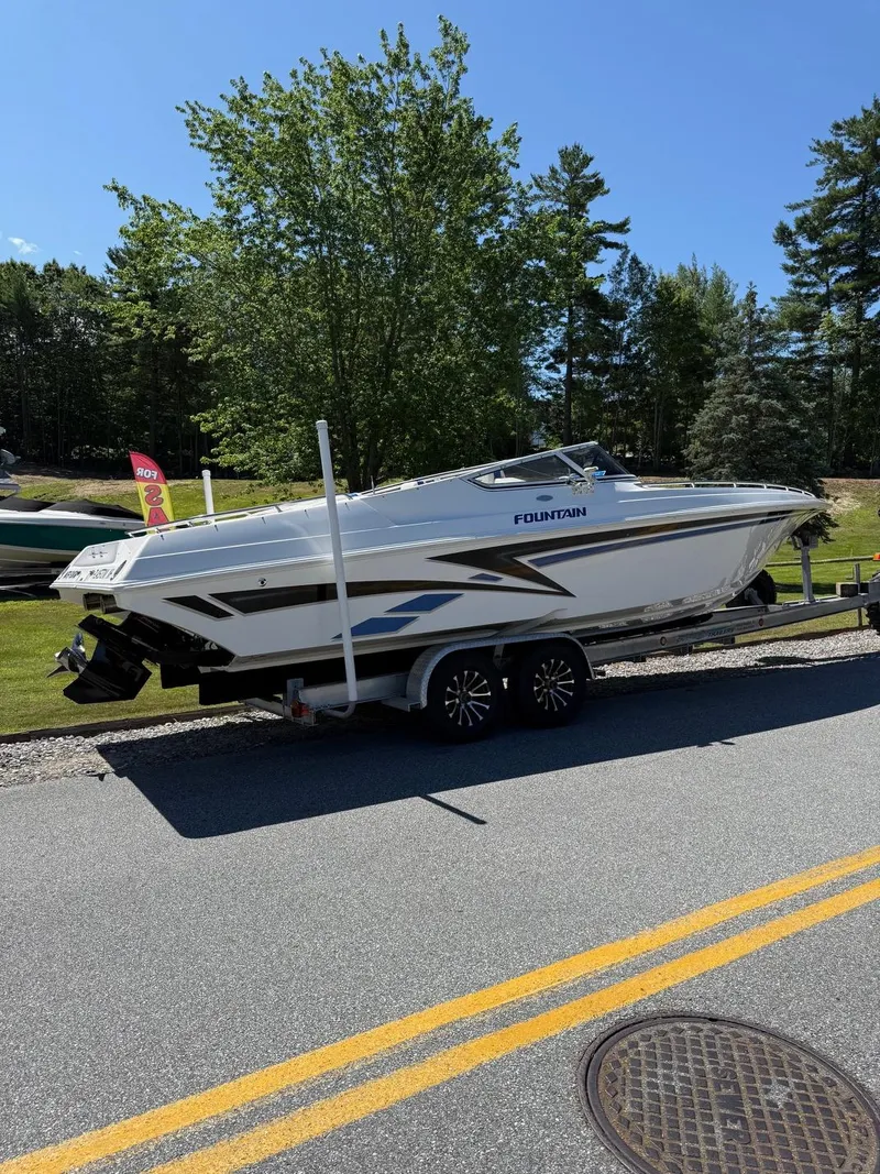 Slide: The Image of 2002 Fountain 29 Fever boat on trailer, parked on roadside with trees in background. - 12