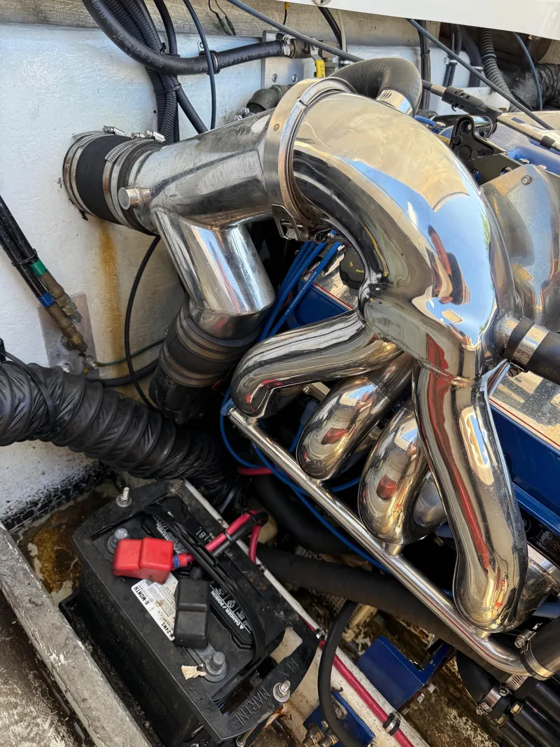 Slide: The Image of Engine compartment of a 2002 Fountain 29 Fever boat, featuring shiny exhaust pipes. - 6