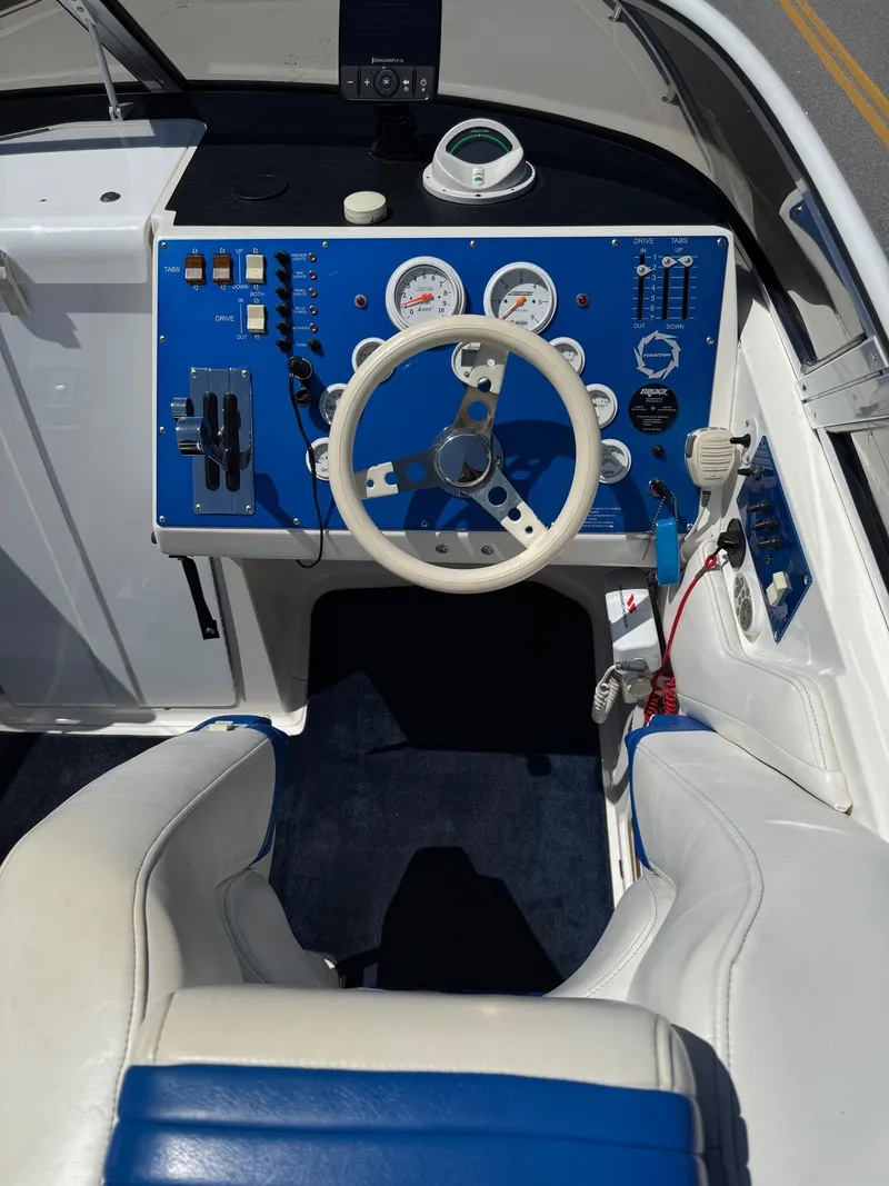Slide: The Image of 2002 Fountain 29 Fever boat cockpit with blue dashboard and white steering wheel. - 7