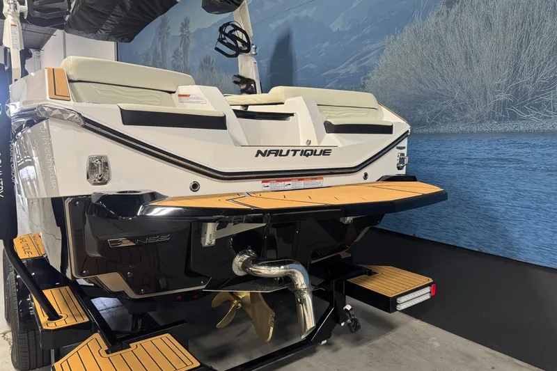 Slide: The Image of 2026 Nautique Super Air Nautique G21 boat rear view with teak platform in showroom. - 5