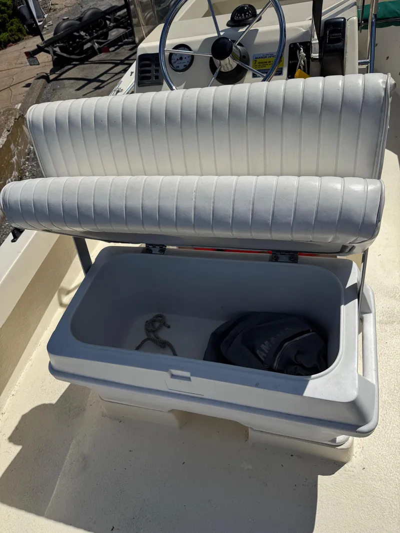 Slide: The Image of Boat seat with storage compartment open, showing rope and bag inside. Eastern 19, 2014 model. - 16