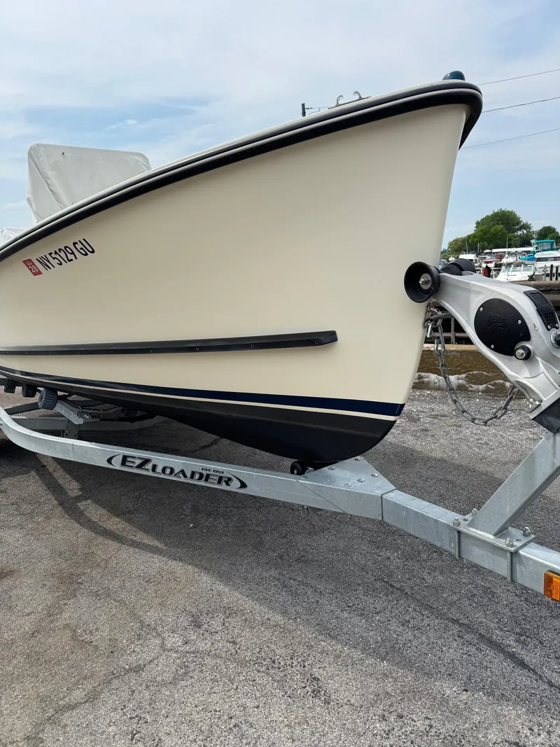 Slide: The Image of 2014 Eastern 19 boat on EZ Loader trailer, parked on concrete surface. - 18