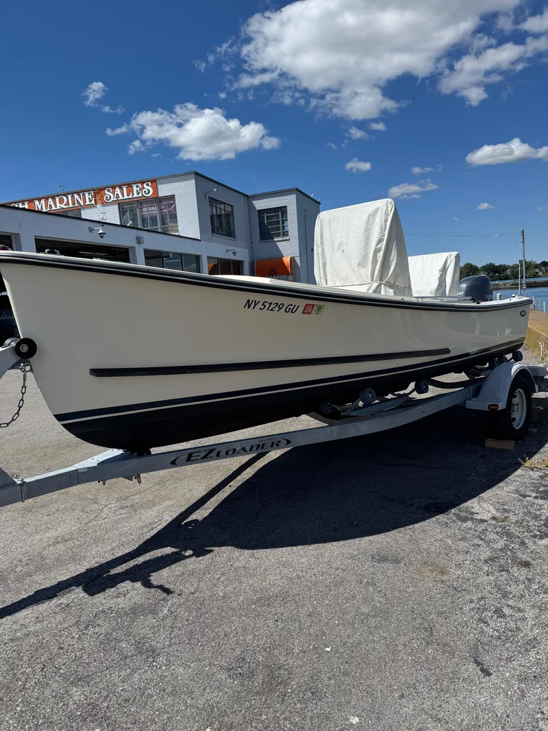 Slide: The Image of 2014 Eastern 19 boat on trailer at marine sales, under clear blue sky. - 2