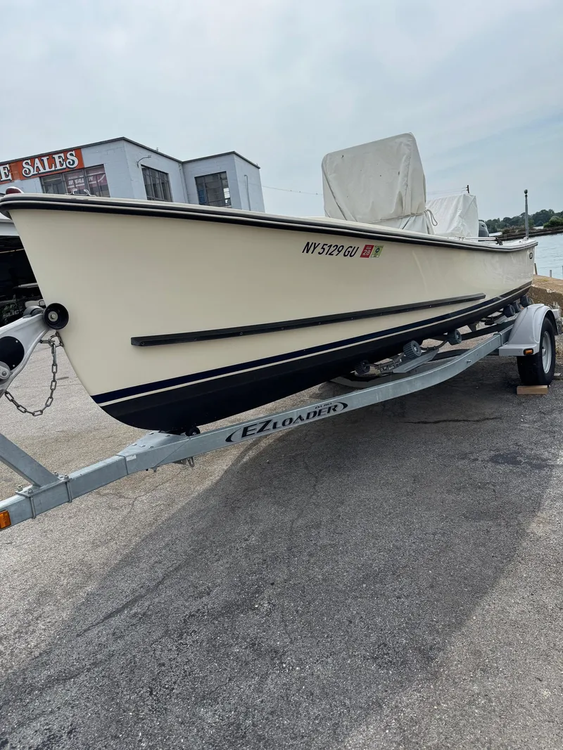 Slide: The Image of 2014 Eastern 19 boat on EZ Loader trailer, parked near a waterfront building. - 4