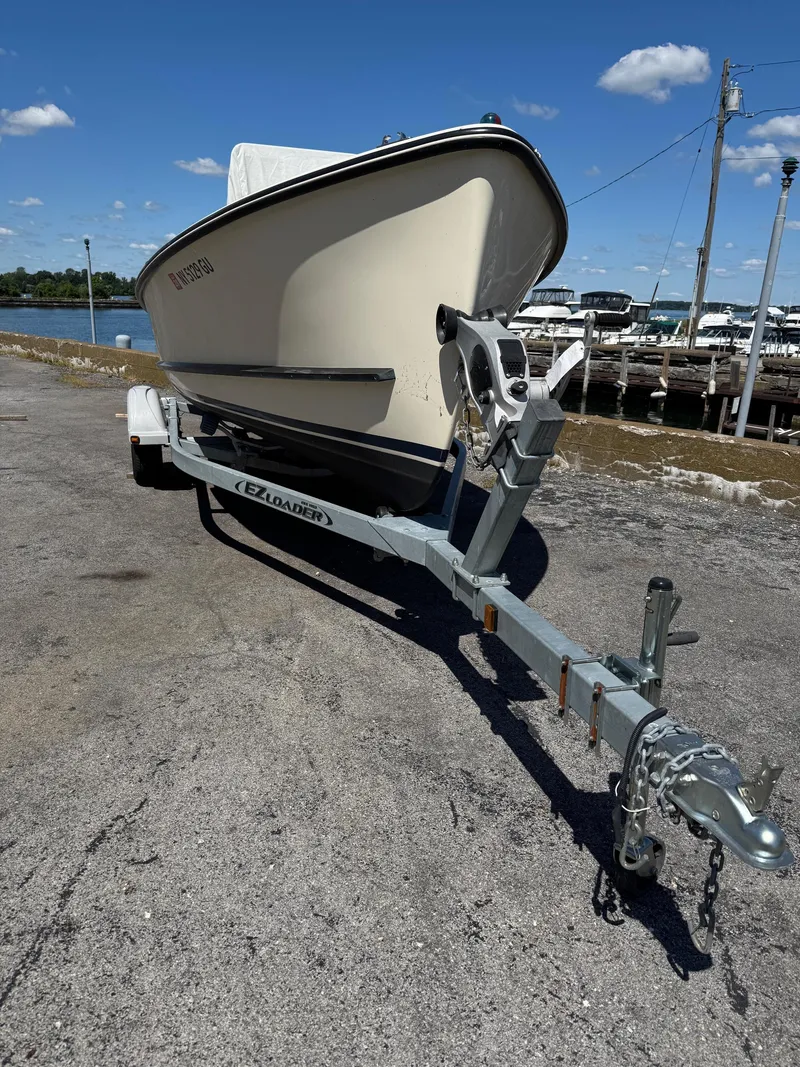 Slide: The Image of 2014 Eastern 19 boat on trailer, parked near waterfront under clear blue sky. - 5