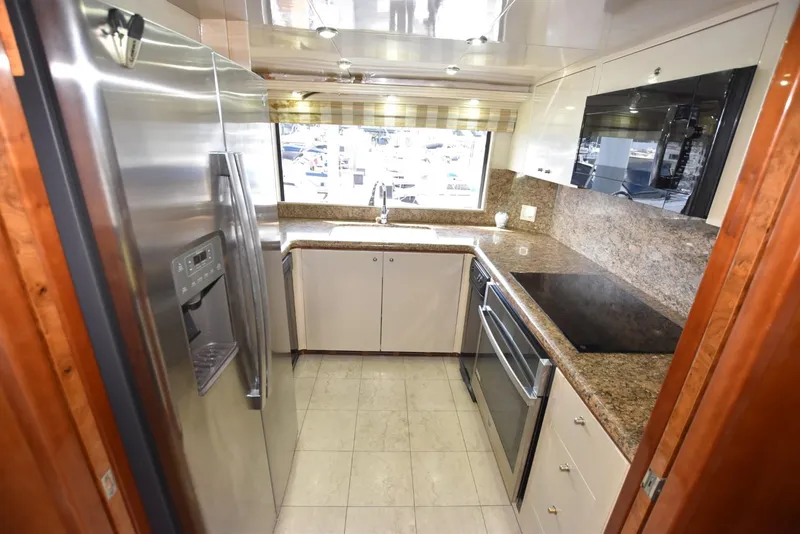 Slide: The Image of Luxurious kitchen in 1998 Hatteras 74 Sport Deck yacht with modern appliances and granite countertops. - 23