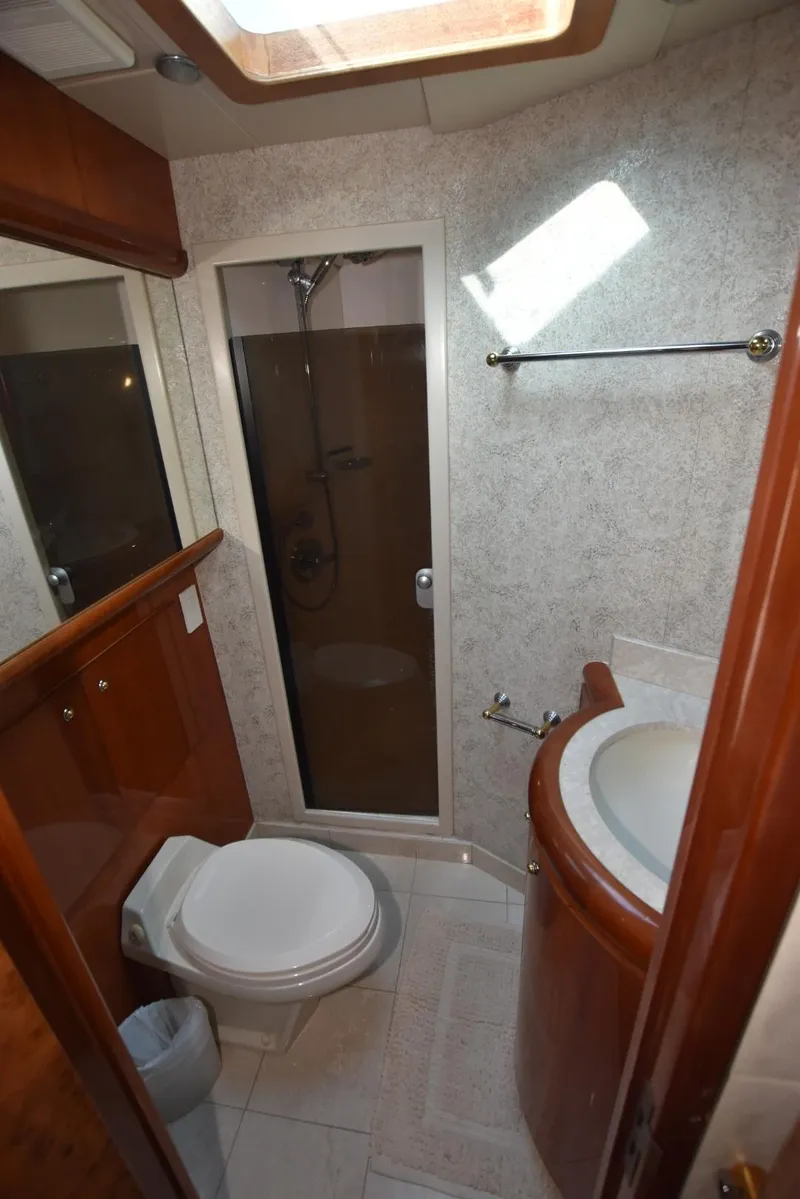 Slide: The Image of Bathroom interior of 1998 Hatteras 74 Sport Deck yacht, featuring shower and toilet. - 30