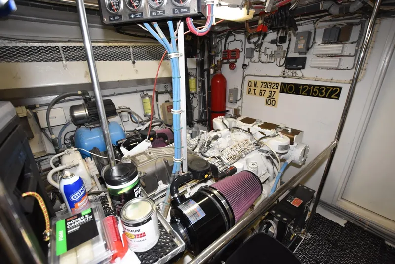 Slide: The Image of Engine room of 1998 Hatteras 74 Sport Deck yacht, featuring machinery and maintenance supplies. - 33