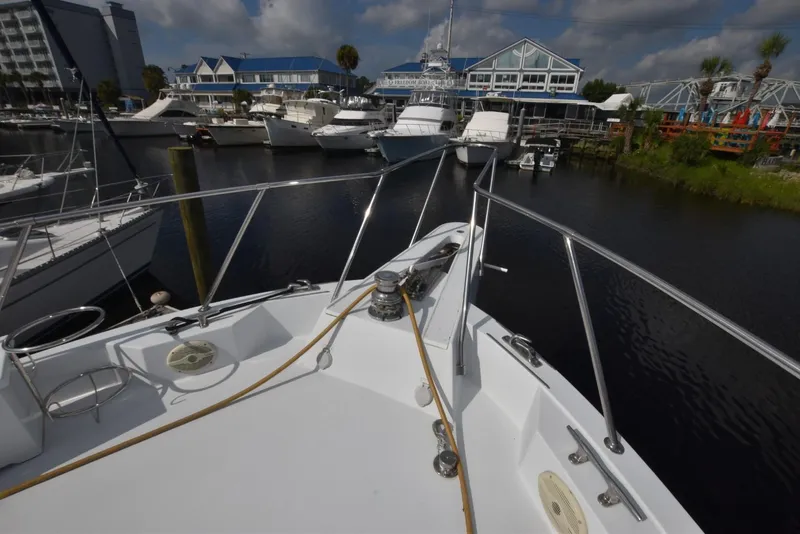 Slide: The Image of Bow view of 1998 Hatteras 74 Sport Deck yacht docked at marina. - 8