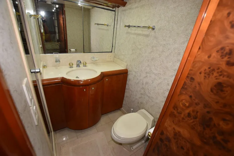 Slide: The Image of Bathroom interior of 1998 Hatteras 74 Sport Deck yacht, featuring wooden cabinetry and modern fixtures. - 27