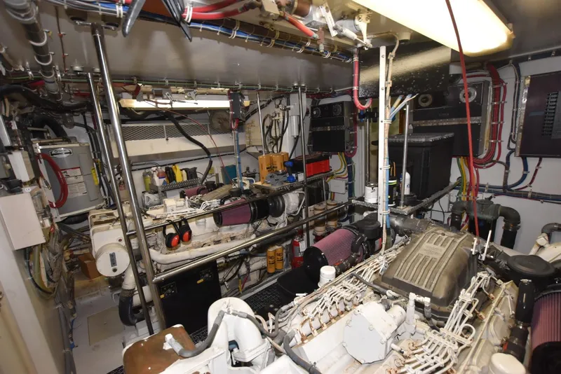 Slide: The Image of Engine room of 1998 Hatteras 74 Sport Deck yacht, showcasing complex machinery and wiring. - 34
