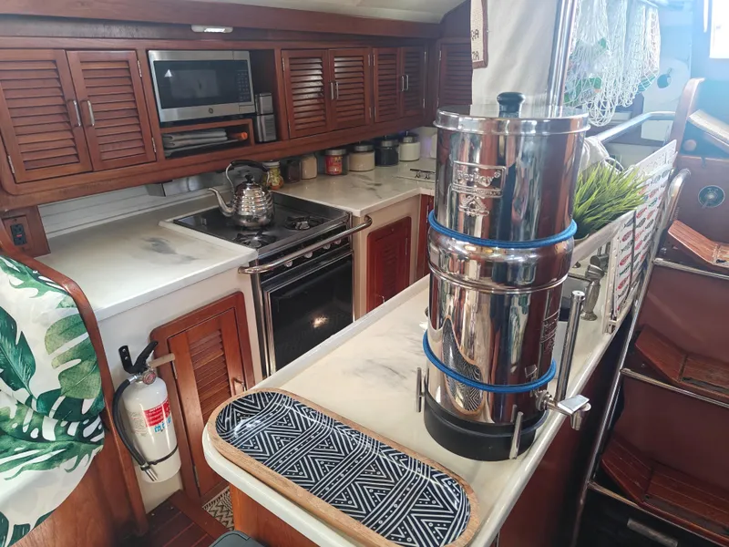 Slide: The Image of 1994 Catalina Morgan yacht kitchen with stove, microwave, and stainless steel water filter. - 3