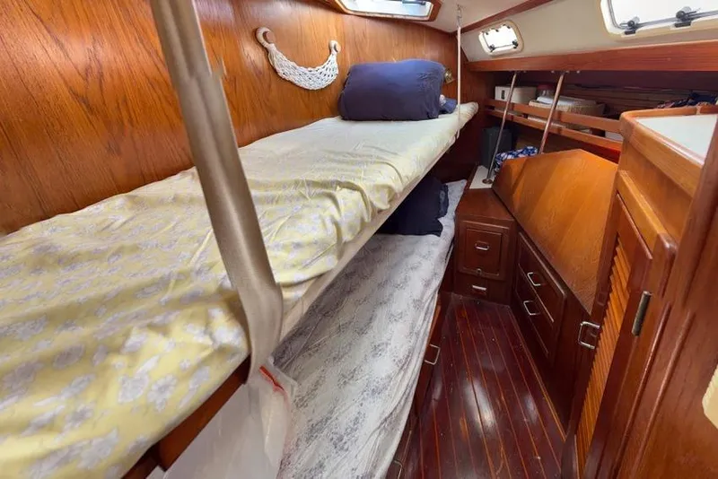 Slide: The Image of Interior of 1994 Catalina Morgan boat with wooden bunk beds and storage cabinets. - 34