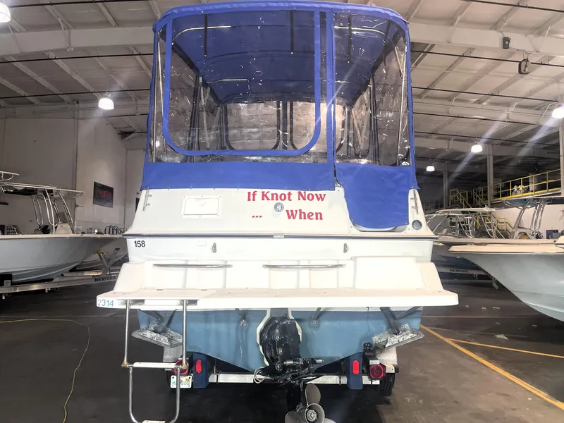 Slide: The Image of 1993 Regal Ambassador 233 boat with blue canopy in a warehouse. - 10
