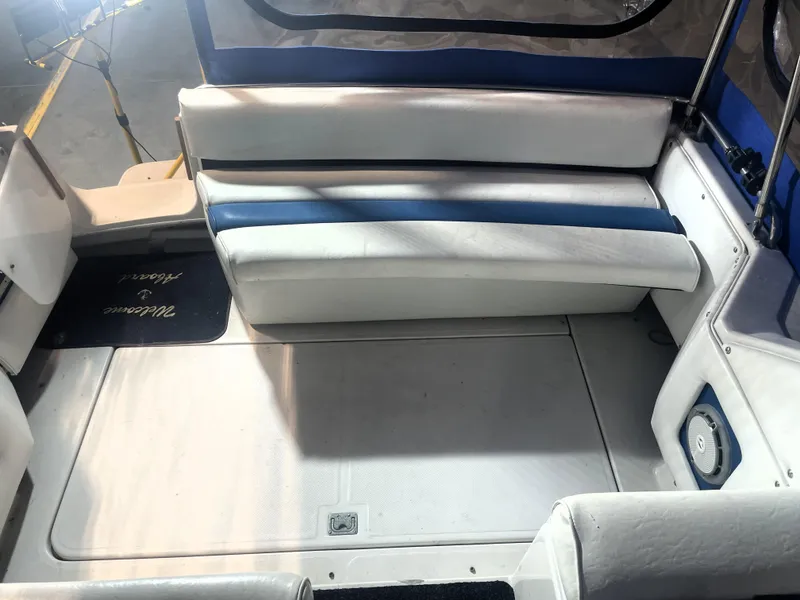 Slide: The Image of 1993 Regal Ambassador 233 boat interior with white and blue seating, spacious deck area. - 18