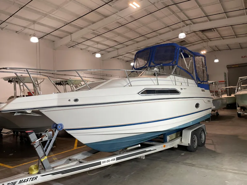 Slide: The Image of 1993 Regal Ambassador 233 boat on trailer in indoor storage facility. - 2