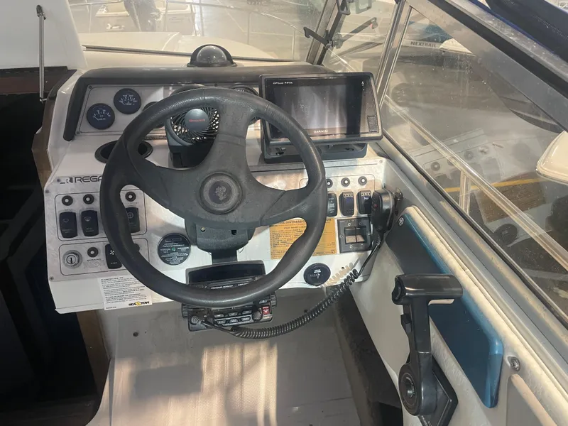 Slide: The Image of 1993 Regal Ambassador 233 boat dashboard with steering wheel and navigation controls. - 22