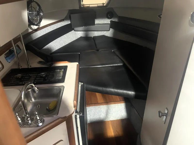 Slide: The Image of 1993 Regal Ambassador 233 boat interior with kitchenette and seating area. - 28