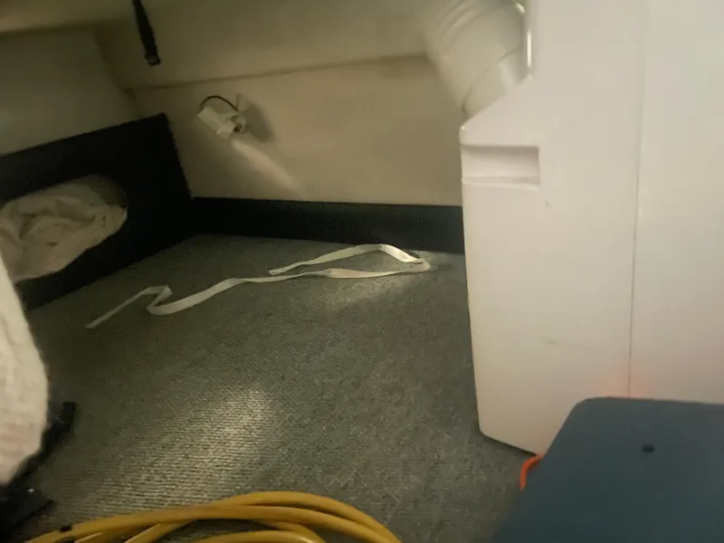 Slide: The Image of Interior of a 1993 Regal Ambassador 233 boat, showing carpeted floor and storage area. - 30