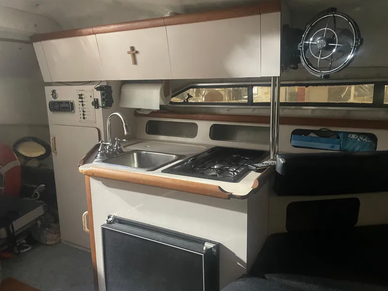 Slide: The Image of Interior of a 1993 Regal Ambassador 233 boat featuring a compact kitchen area. - 31