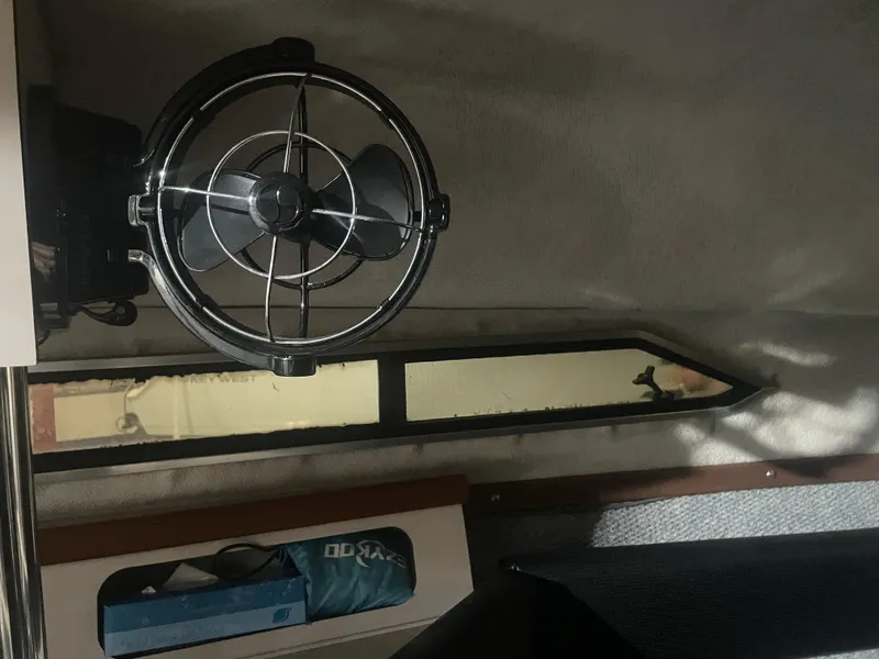 Slide: The Image of Interior of a 1993 Regal Ambassador 233 boat with a mounted fan and window. - 36