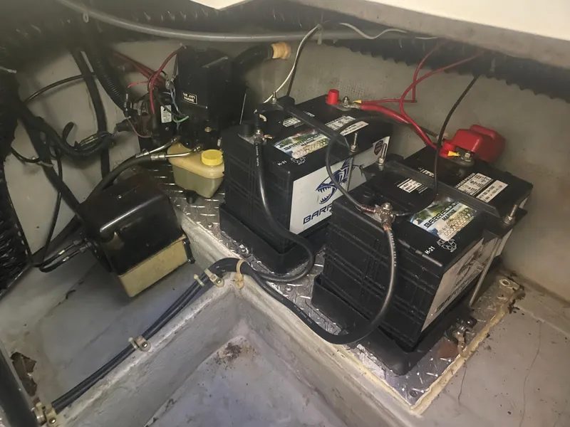 Slide: The Image of Battery compartment of a 1993 Regal Ambassador 233 boat, featuring dual batteries and wiring. - 43