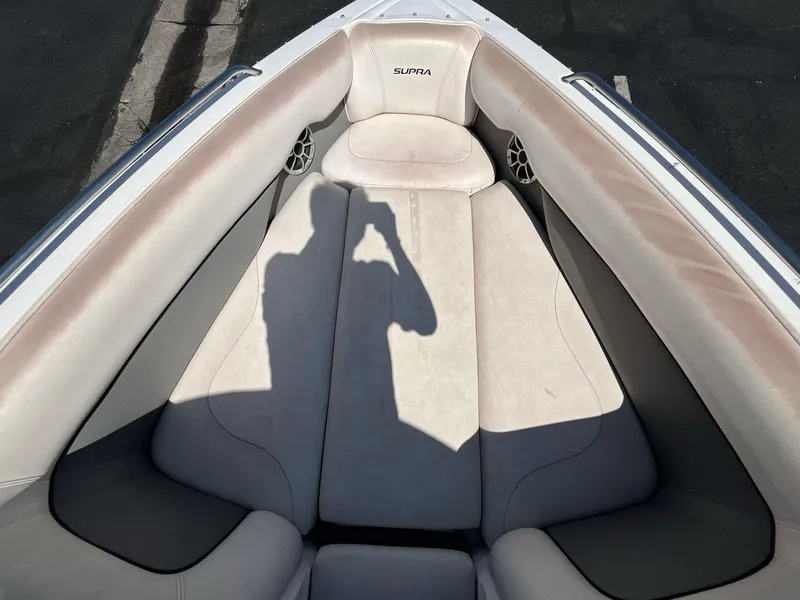 Slide: The Image of 2009 Supra Launch 24 SSV boat interior with beige seating and shadow. - 11