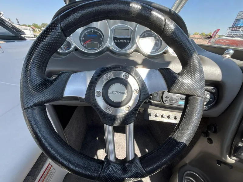 Slide: The Image of 2009 Supra Launch 24 SSV steering wheel and dashboard with gauges and controls. - 14