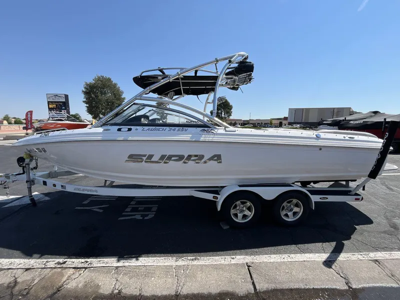Slide: The Image of 2009 Supra Launch 24 SSV boat on trailer in parking lot, sunny day. - 2