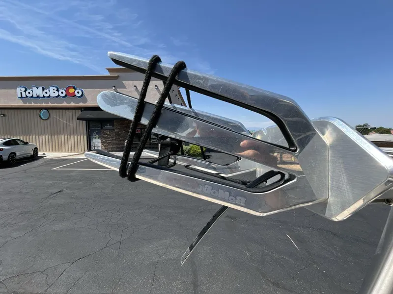 Slide: The Image of 2009 Supra Launch 24 SSV boat detail near RoMoBoCo building, clear sky background. - 22