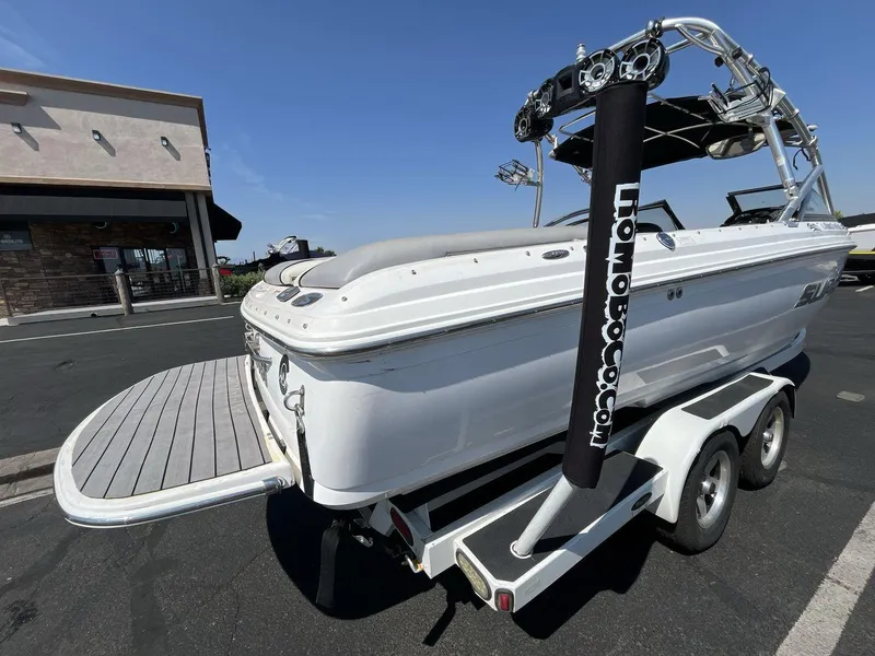 Slide: The Image of 2009 Supra Launch 24 SSV boat on trailer, parked near a building. - 5