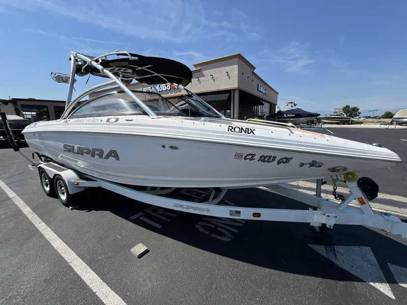 Slide: The Image of 2009 Supra Launch 24 SSV boat on trailer in parking lot, sunny day. - 7