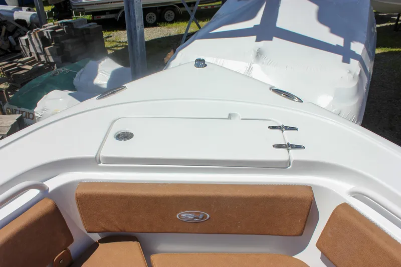 Slide: The Image of 2026 Sea Hunt Ultra 245 SE boat interior with cushioned seating and storage compartment. - 17